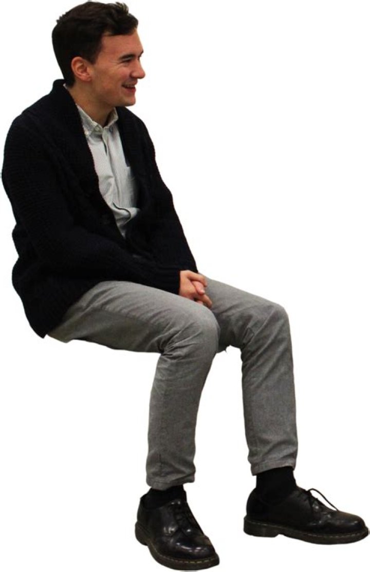 a man sitting on top of a stage with a microphone in his hand and mouth